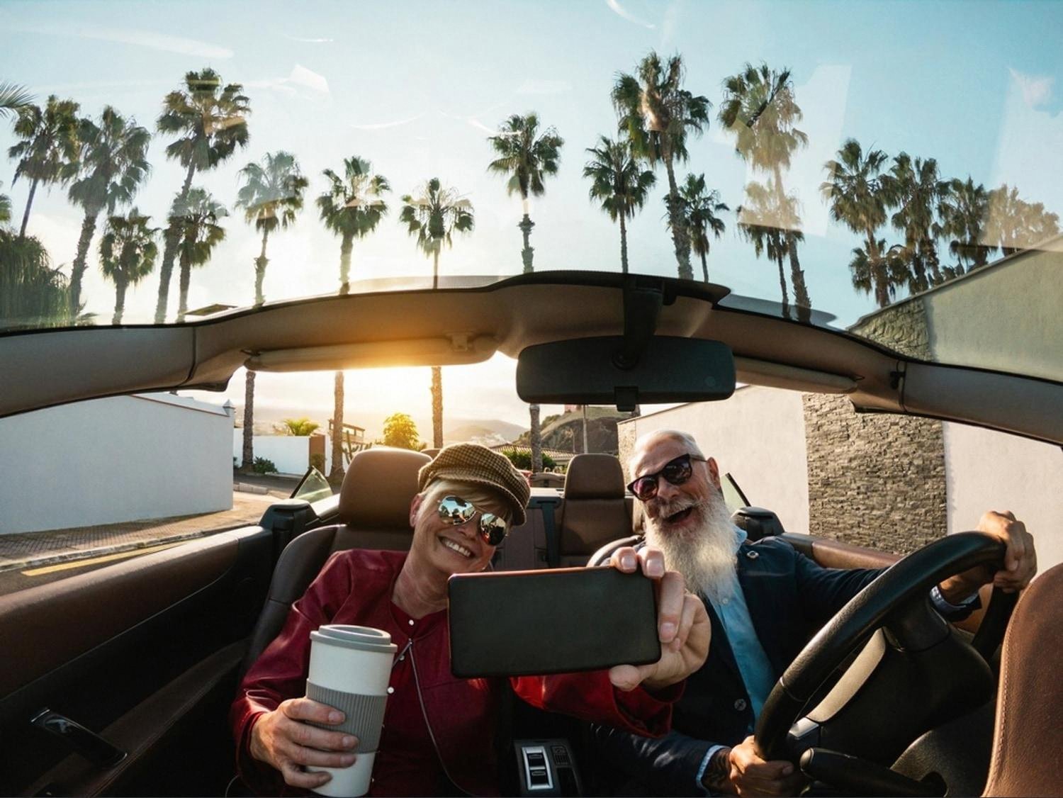 Older couple taking a selfie inside a convertible during a long road trip in Australia